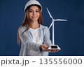 Woman engineer electrician is holding toy wind generator 135556000