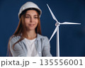 Woman engineer electrician is holding toy wind generator 135556001