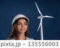Woman engineer electrician is holding toy wind generator 135556003