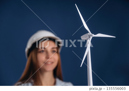 Woman engineer electrician is holding toy wind generator 135556003