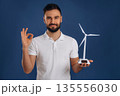 Electrician is holding wind generator toy, conception of eco energy 135556030