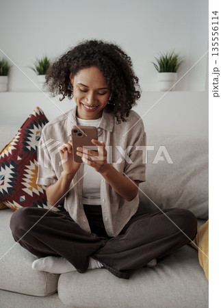 Woman Reading Smiling, Young Lady Enjoying Phone Message, Girl Relaxing On Couch With Gentle Smile Woman Reading Smiling, Young Lady Enjoying Phone Message, Girl Relaxing On Couch With Gentle Smile 135556114