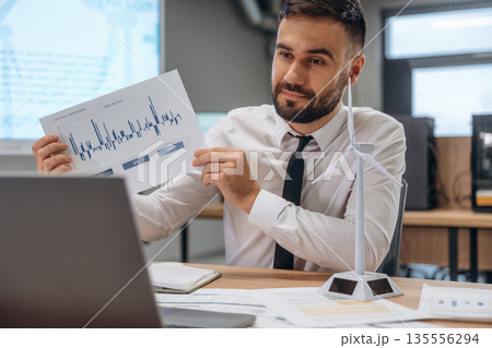 Graphs on the paper. Man is working in the wind turbine company Graphs on the paper. Man is working in the wind turbine company 135556294
