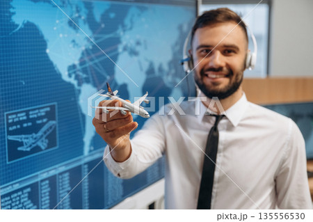 Cheerful facial expression. Man is holding toy plane, in airline company 135556530