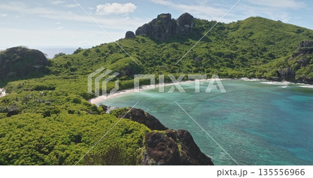 Fiji: Aerial drone view of secluded tropical bay with turquoise water, pristine sandy beach and lush green hills, perfect peaceful island paradise for travel and vacation. Aerial view drone flight 135556966