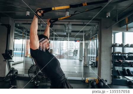 Flexibility and strength. Man is in the modern gym Flexibility and strength. Man is in the modern gym 135557058