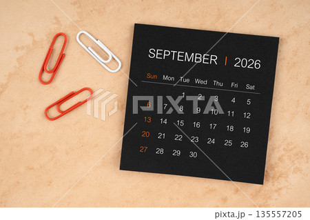 Black calendar sheet for September 2026 with paper clips on paper. 135557205