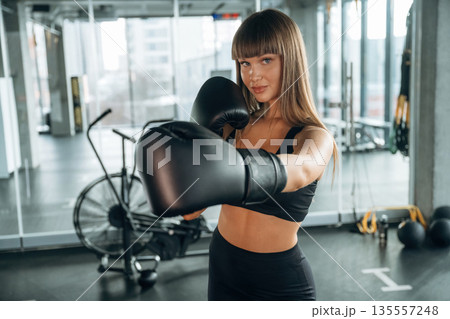 Boxing training session. Young woman is in the gym Boxing training session. Young woman is in the gym 135557248