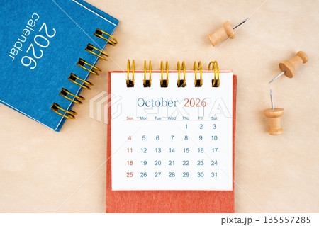 October 2026 desk calendar with wooden thumbtack on brown paper. 135557285