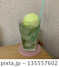 氷入りグラスに注いだメロンソーダとメロンアイスクリームとピンクのコースター 135557602