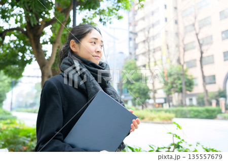 街中でノートパソコンを持つ日本人女性 街中でノートパソコンを持つ日本人女性 135557679