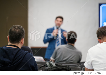 Professional speaker delivers presentation to attentive audience at conference room seminar setting during business meeting Professional speaker delivers presentation to attentive audience at conference room seminar setting during business meeting 135557825