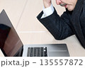 ノートPCの前で悩むスーツ姿のシニア男性 135557872