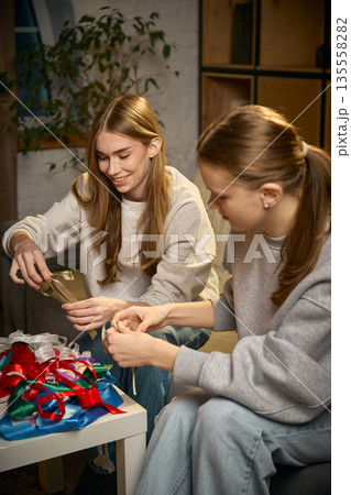 Two sisters working together on decorative handmade project at home 135558282