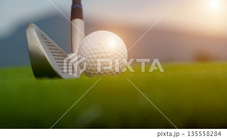Golf clubs and golf balls on a green lawn in a beautiful golf course with morning sunshine. Golf clubs and golf balls on a green lawn in a beautiful golf course with morning sunshine. 135558284