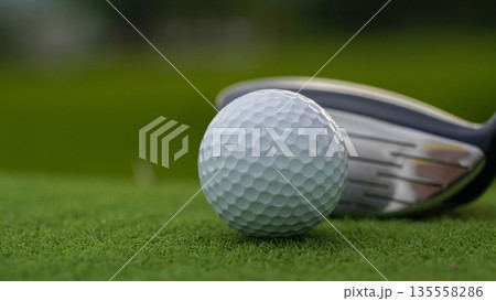 Golf clubs and golf balls on a green lawn in a beautiful golf course with morning sunshine. Golf clubs and golf balls on a green lawn in a beautiful golf course with morning sunshine. 135558286