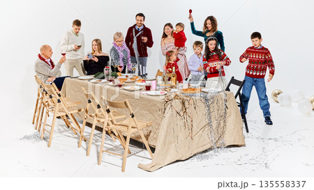 Multi generation family enjoying festive meal during winter holidays. Multi generation family enjoying festive meal during winter holidays. 135558337