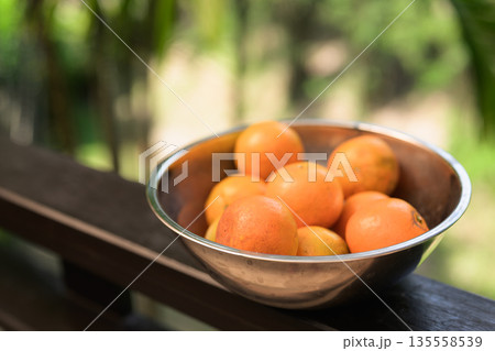 Fresh Oranges in Bowl with Tropical Leaves Background for Healthy Lifestyle Concept Fresh Oranges in Bowl with Tropical Leaves Background for Healthy Lifestyle Concept 135558539