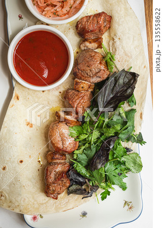 Lamb shashlik served with flatbread and herbs 135558622