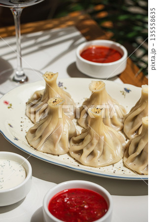 Georgian khinkali dumplings served with sauces Georgian khinkali dumplings served with sauces 135558635