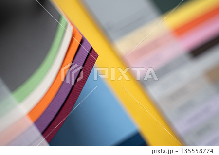 Closeup of layered print production sampler with textured paper swatches in various colors Closeup of layered print production sampler with textured paper swatches in various colors 135558774