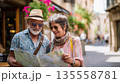 Mature couple visiting picturesque city street on holiday, reading map sightseeing  135558781