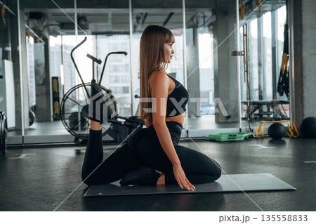 Stretching the legs. Young woman is in the gym Stretching the legs. Young woman is in the gym 135558833