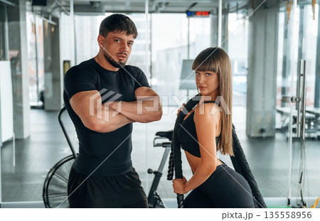Standing and posing. Man and woman are in the gym together 135558956