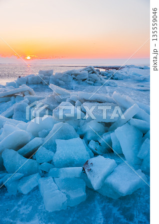 Frozen ocean with stacked ice slabs at sunset 135559046