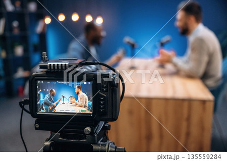 Interviewing the musician. Two radio presenters recording an audio broadcast in a studio 135559284