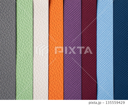 Closeup of layered print production sampler with textured paper swatches in various colors Closeup of layered print production sampler with textured paper swatches in various colors 135559429