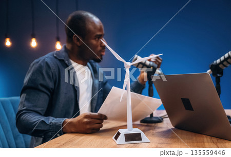 Air turbine model on the table. Man is doing podcast in the studio Air turbine model on the table. Man is doing podcast in the studio 135559446