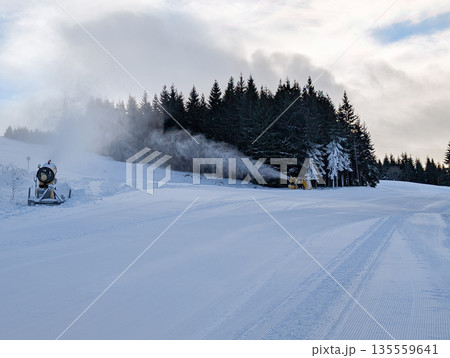 Snowmaking system operating along forested ski slope in Kopaonik. Artificial snow production, climate adaptation, and winter sport sustainability through technology and mountain infrastructure. Snowmaking system operating along forested ski slope in Kopaonik. Artificial snow production, climate adaptation, and winter sport sustainability through technology and mountain infrastructure. 135559641