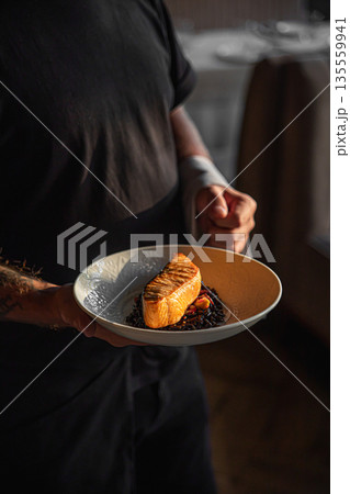 Grilled salmon fillet served by chef on plate Grilled salmon fillet served by chef on plate 135559941