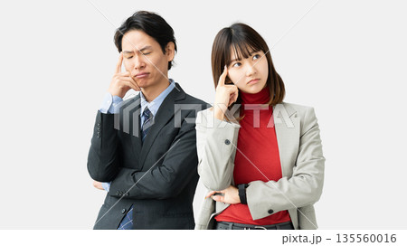 考えごとをする男女2人のビジネスマン 考えごとをする男女2人のビジネスマン 135560016