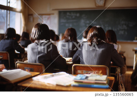 夕暮れの教室で勉強する女子生徒の後ろ姿　日本の学校のノスタルジックな風景 135560065