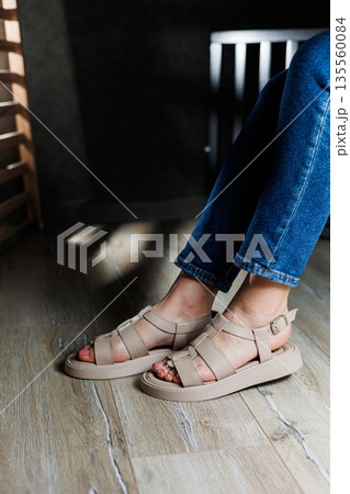 Summer women's sandals. Collection of women's leather summer sandals. Slender female legs in beige leather sandals without heels. Summer women's sandals. Collection of women's leather summer sandals. Slender female legs in beige leather sandals without heels. 135560084