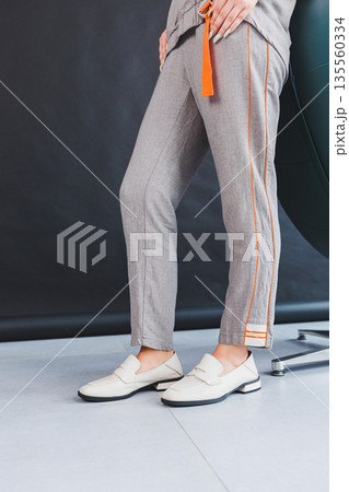 Beige women's leather shoes close-up on female legs. New collection of women's summer leather shoes. Beige women's leather shoes close-up on female legs. New collection of women's summer leather shoes. 135560334