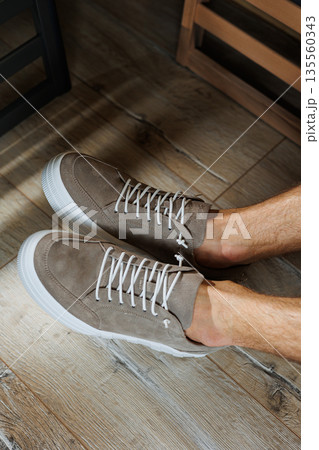 Collection of men's summer shoes. Male legs in beige leather sneakers. Men's classic shoes. Collection of men's summer shoes. Male legs in beige leather sneakers. Men's classic shoes. 135560343