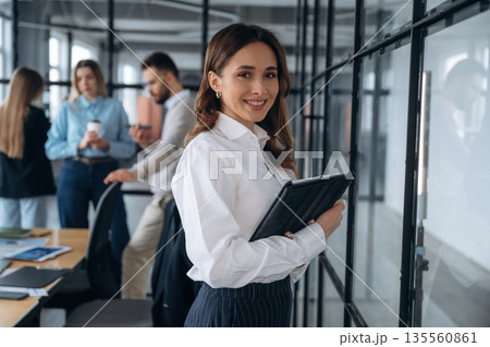 In white shirt and black pants. Business people are working in the office In white shirt and black pants. Business people are working in the office 135560861