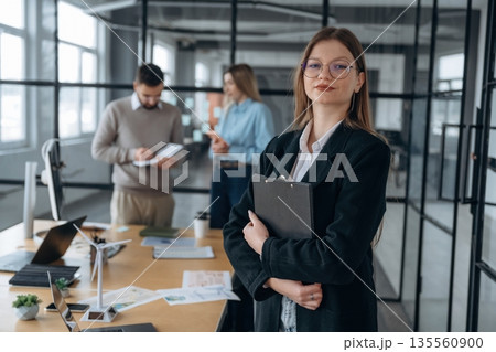 Female employee is posing. Business people are working in the office 135560900