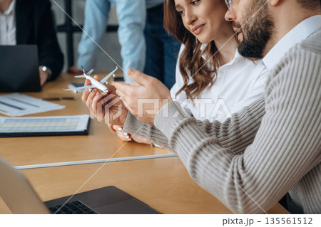 Airline company, with toy plane. Business people are working in the office Airline company, with toy plane. Business people are working in the office 135561512