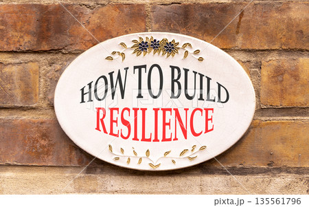 How to build resilience symbol. Concept words How to build resilience on beautiful white sign plate. Beautiful brick wall background. Business how to build resilience concept. Copy space. 135561796