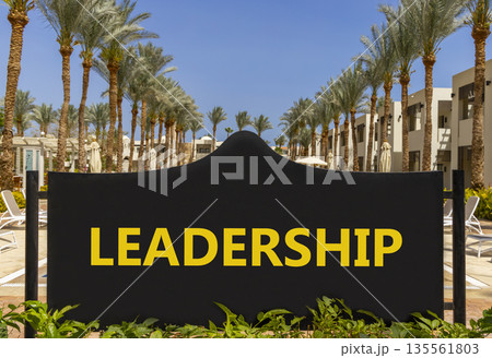 Leadership symbol. Concept word Leadership on beautiful big black road sign. Beautiful blue sky and palm trees background. Business leadership concept. Copy space. Leadership symbol. Concept word Leadership on beautiful big black road sign. Beautiful blue sky and palm trees background. Business leadership concept. Copy space. 135561803