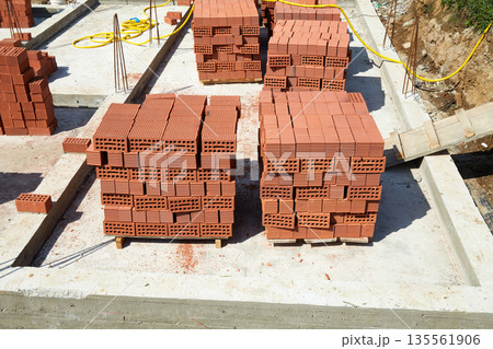 Bricks stacked neatly at a construction site in daylight preparing for building construction activity Bricks stacked neatly at a construction site in daylight preparing for building construction activity 135561906