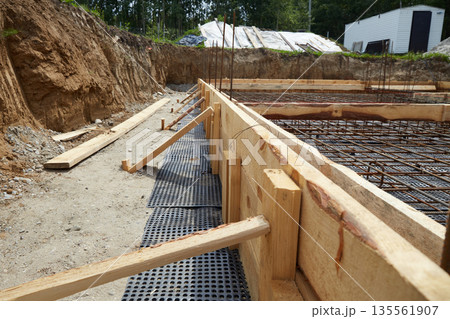 Steel reinforcement is placed in wooden molds and formwork on a construction site Steel reinforcement is placed in wooden molds and formwork on a construction site 135561907