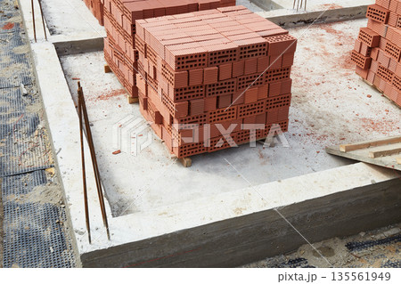 Bricks are neatly stacked on the construction site. Preparing materials for the construction of the building Bricks are neatly stacked on the construction site. Preparing materials for the construction of the building 135561949