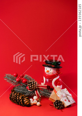 Festive Snowman and Pine Cones on Red Christmas Background 135562185