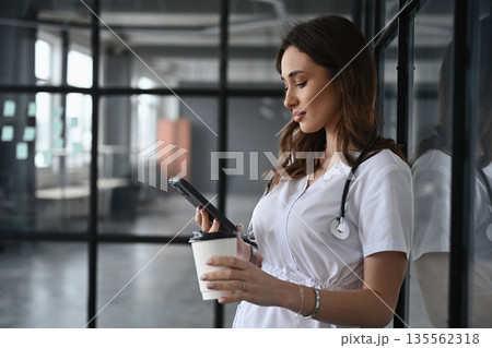 Coffee break, with cup. Woman doctor is in the office Coffee break, with cup. Woman doctor is in the office 135562318