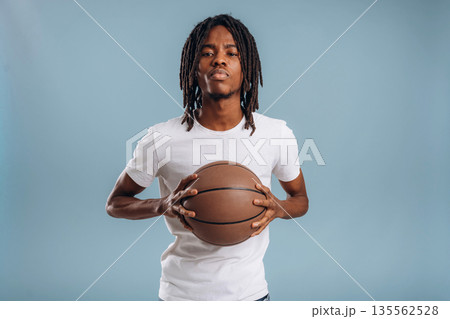 Game of basketball. Black man is in the studio against soft background Game of basketball. Black man is in the studio against soft background 135562528